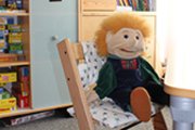 Puppe auf einem Suhl sitzend